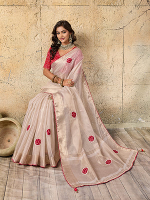 A white saree with red beads work and cutdana embellishments.