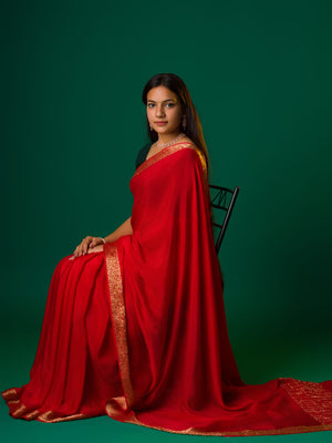 A red saree with a zari border
