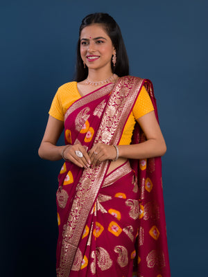 A maroon saree with gold patterns with Dola Silk Bandhani Zari Weaving Work