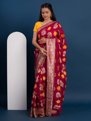 A maroon saree with gold patterns with Dola Silk Bandhani Zari Weaving Work