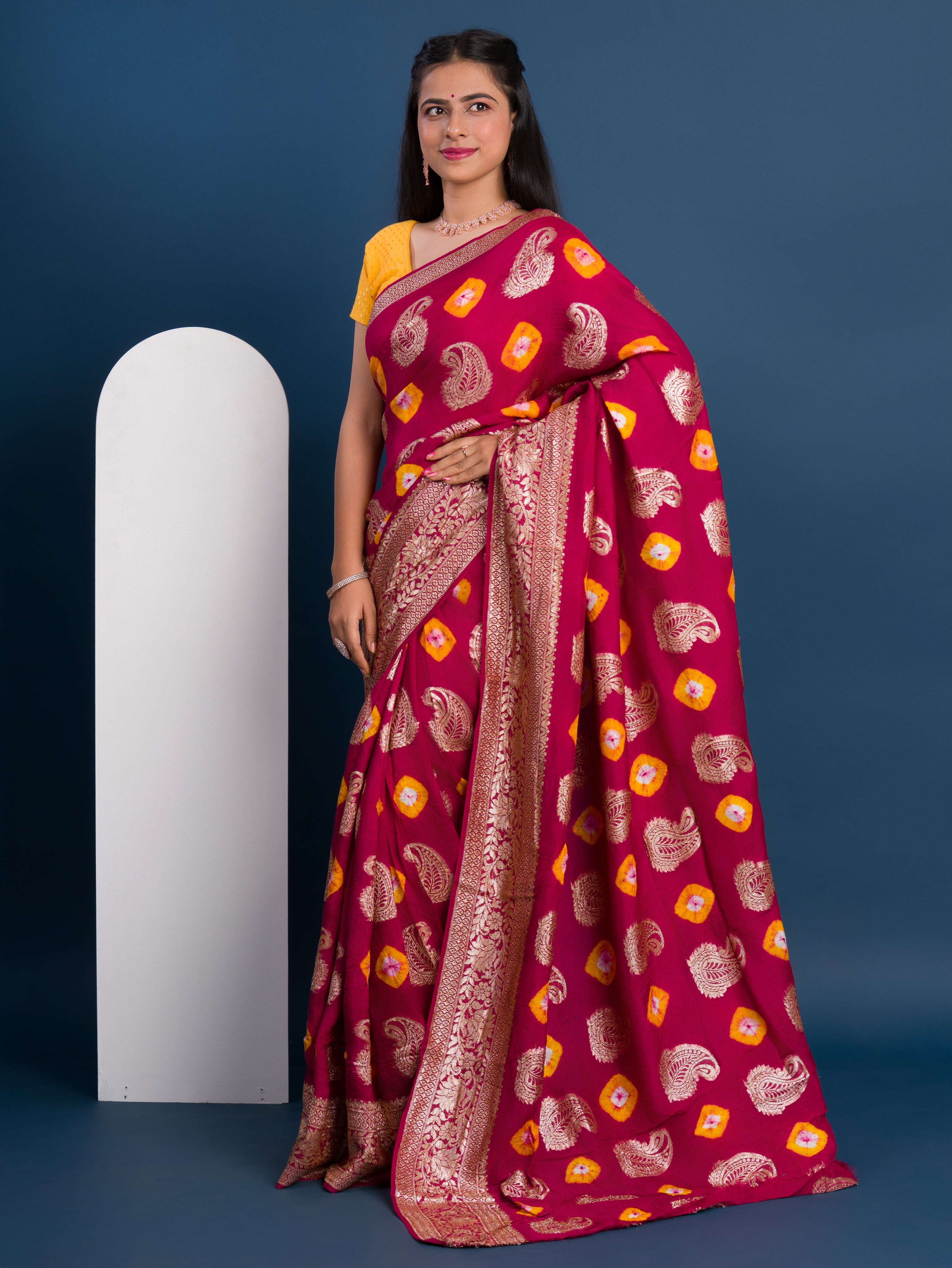 A maroon saree with gold patterns with Dola Silk Bandhani Zari Weaving Work