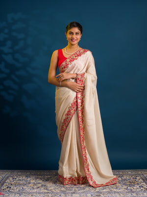 A white chinon silk Bollywood style saree with embellishments and gotapatti work