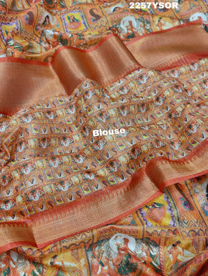 A saree with a kalamkari style pattern in orange and green colors, with zari weaving and a Banarasi border.