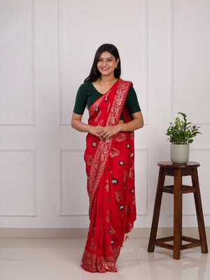 A red saree with green patterns with Dola Silk Bandhani Zari Weaving Work