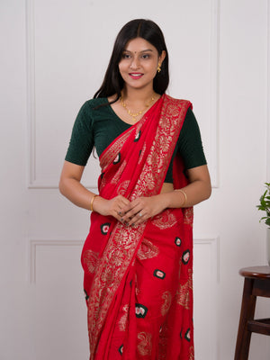 A red saree with green patterns with Dola Silk Bandhani Zari Weaving Work
