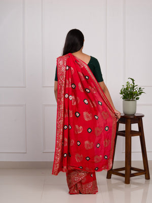 A red saree with green patterns with Dola Silk Bandhani Zari Weaving Work