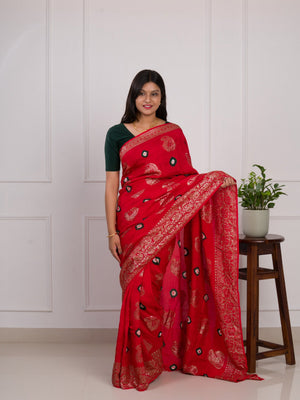 A red saree with green patterns with Dola Silk Bandhani Zari Weaving Work