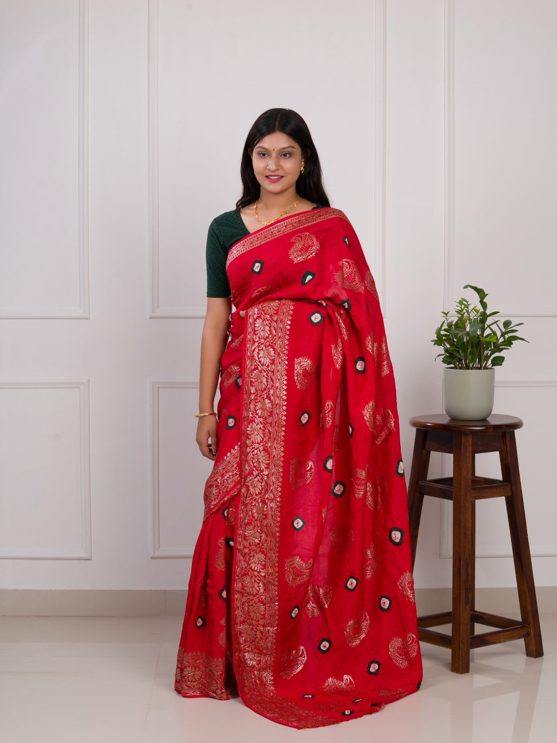 A red saree with green patterns with Dola Silk Bandhani Zari Weaving Work