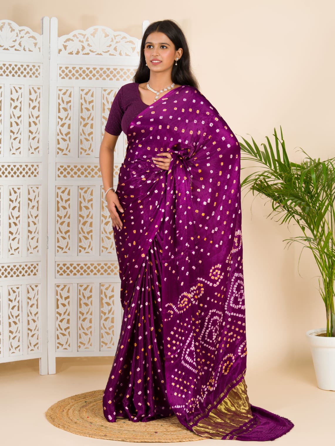 A purple and pink bandhani saree with a lagdi pattern on the pallu,