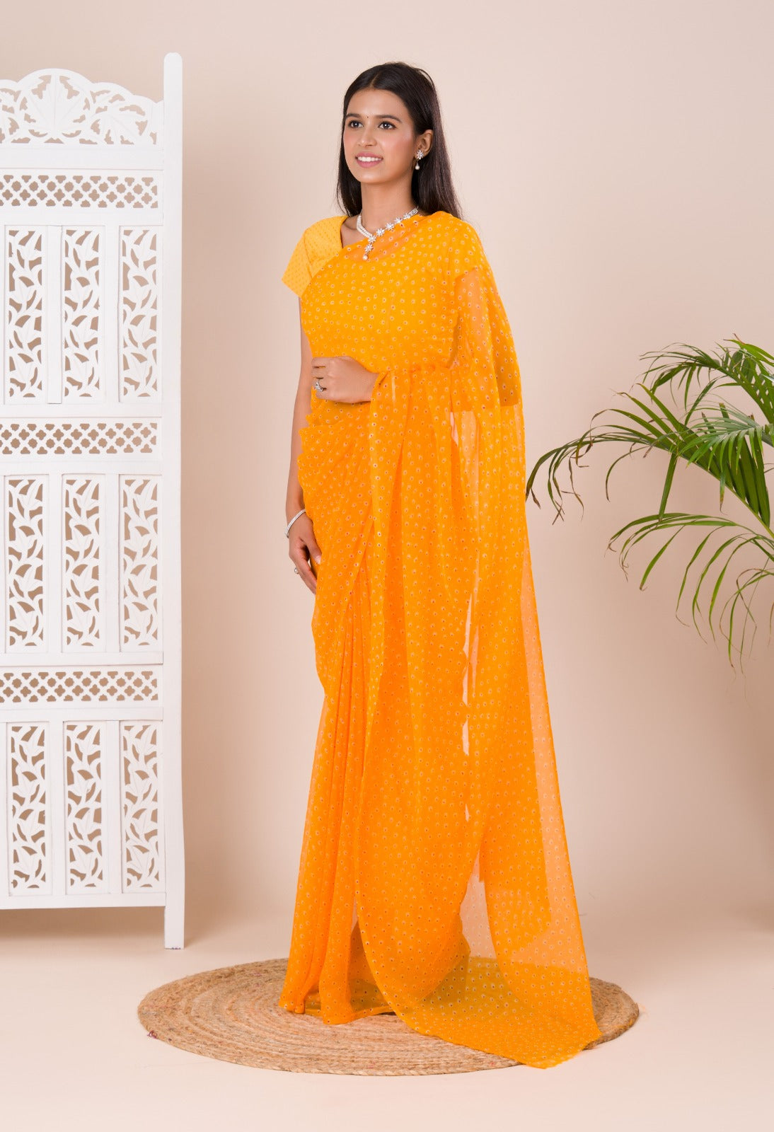 A yellow chiffon saree with a bandhani pattern