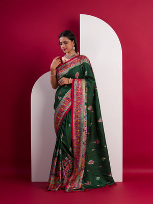 A green saree with a colorful border in Dola Silk Kalamkari Style