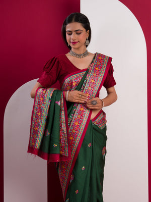 A green saree with a colorful border in Dola Silk Kalamkari Style
