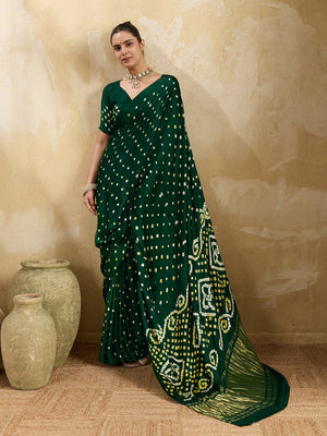 A bottle green saree with bandhani print and lagdi patola pallu, alongside a blouse piece.